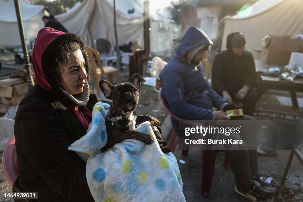Woman sits near a makeshift tent with her dog at a camp on February 11, 2023 in Hatay, Turkey. A 7.8-magnitude earthquake hit near Gaziantep, Turkey,...