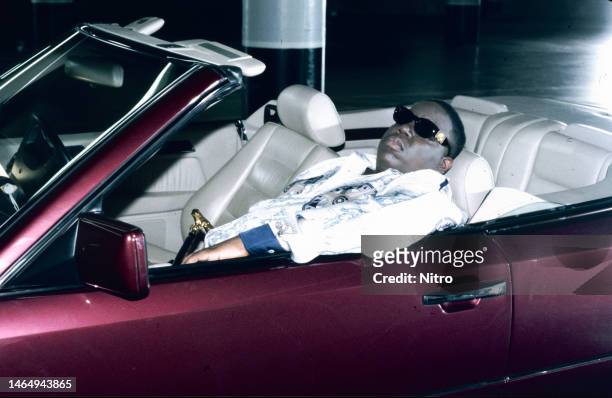 American rapper Notorious BIG sits in convertible on the set his 'Hypnotize' music video, Los Angeles California, February 1997.