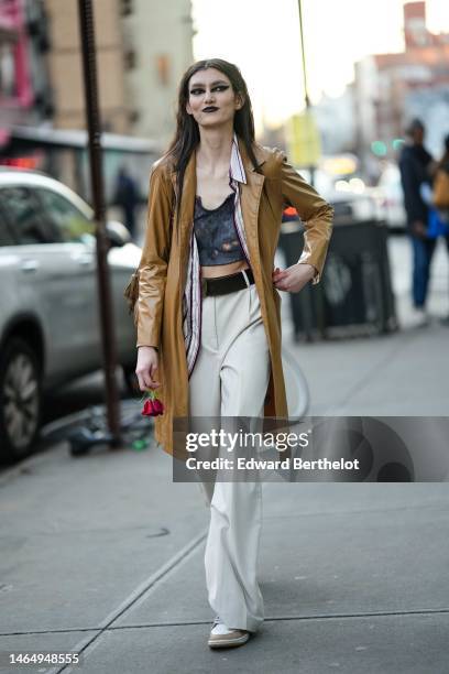 Model wears a black and gray tie and dye print pattern ribbed V-neck / cut-out / cropped tank-top, a white with black and red striped print pattern...