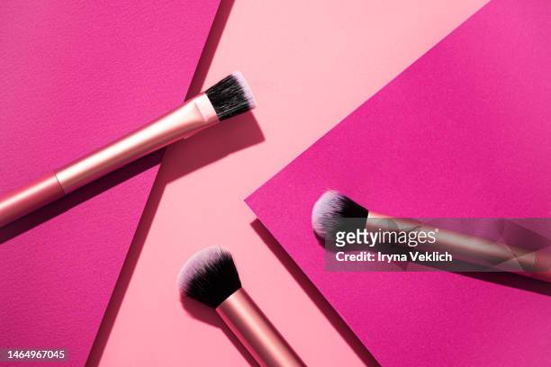 set of multi-functional makeup brush on pastel pink and  viva magenta color of the 2023 year background. face foundation application tool makeup products. - eye shadow stock pictures, royalty-free photos & images