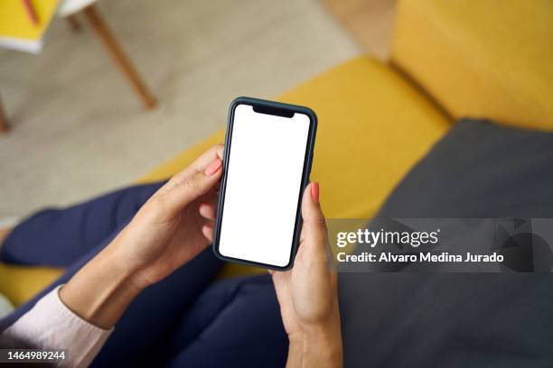 top view of an unrecognizable woman's hands using her mobile phone with a blank screen. - man holding phone stock-fotos und bilder