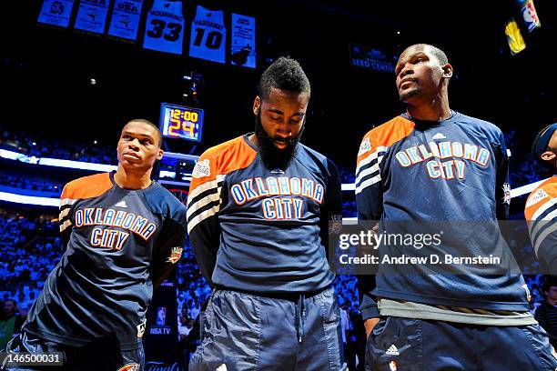 Oklahoma City Thunder players, from left, Russell Westbrook, James Harden and Kevin Durant listen during the National Anthem before facing the Miami...