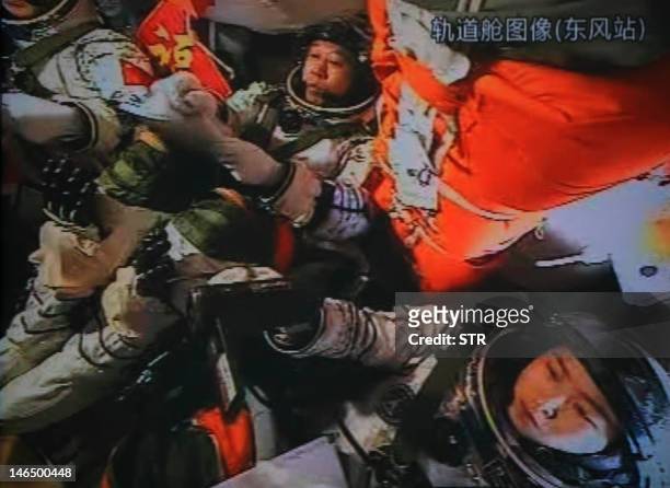 Photo of the giant screen at the Jiuquan space center shows three Chinese astronauts Liu Wang, Jing Haipeng and Liu Yang in the Shenzhou-9 spacecraft...
