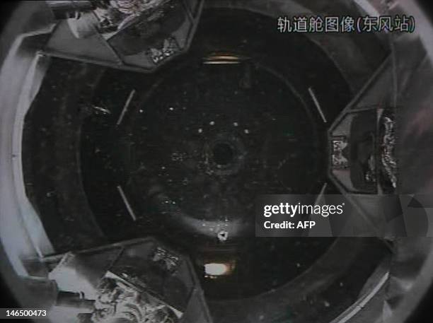 Photo of the giant screen at the Jiuquan space center shows the Tiangong-1 module being filmed from the Shenzhou-9 spacecraft before the automatic...