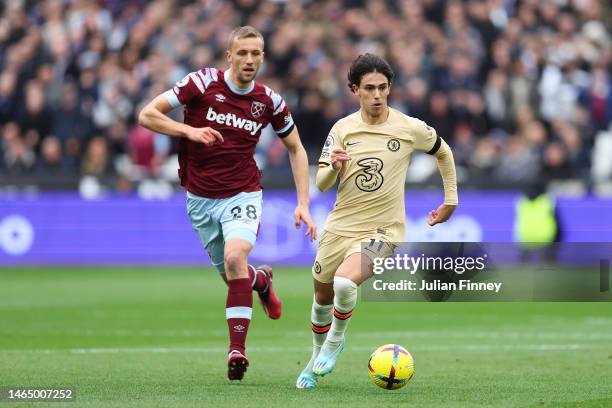 Joao Felix of Chelsea runs with the ball while under pressure from Tomas Soucek of West Ham United during the Premier League match between West Ham...