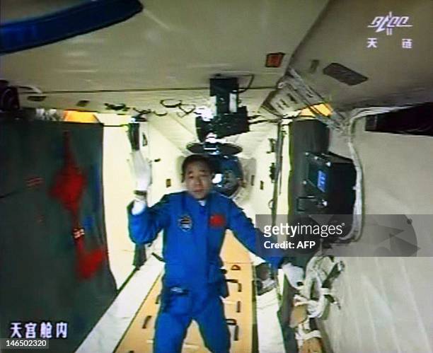 Photo of the giant screen at the Jiuquan space center shows mission commander Jing Haipeng in the Tiangong-1 module on June 18, 2012. Three Chinese...
