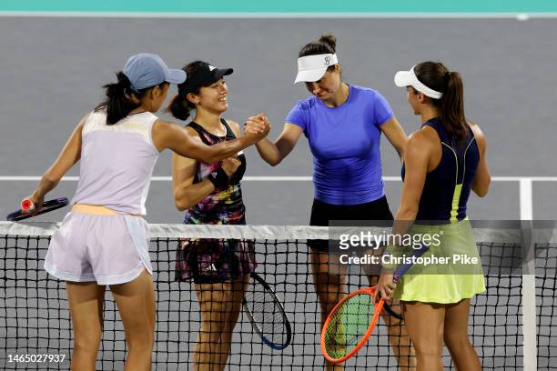 Luisa Stefani of Brazil and Shuai Zhang of China shake hands after defeating Miyu Kato of Japan and Monica Niculescu of Romania during their Women's...