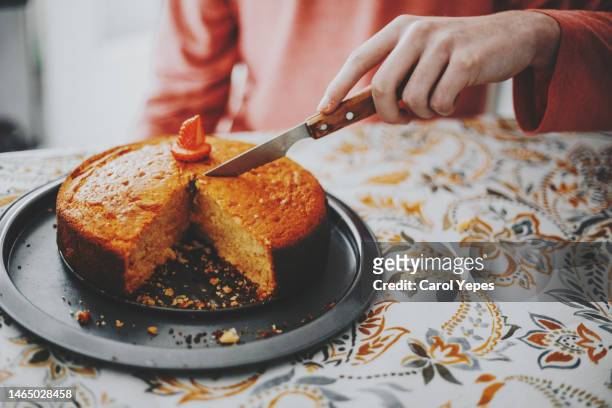 unrecognizable person cutting homemade lemon cake - dessertpasteten stock-fotos und bilder