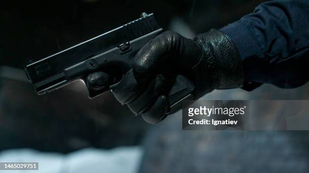 close-up of a gun in hand - handgun stock pictures, royalty-free photos & images