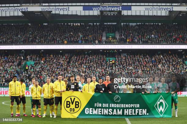 Borussia Dortmund and SV Werder Bremen Players and officials hold a banner for the victims of an earthquake in Turkey and Syria prior to the...