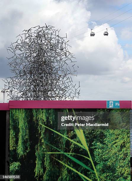 The Emirates Air Line cable car over the the River Thames passes in sight of Antony Gormley's sculpture Quantum Cloud during testing on June 18, 2012...