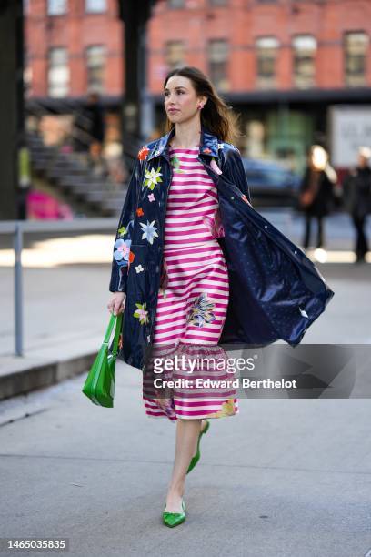 Guest wears pink flower earrings, a pink and white striped print pattern with large embroidered flower pattern midi dress, a navy blue with...
