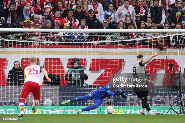 Finn Dahmen of 1.FSV Mainz 05 fails to stop a goal scored by Ermedin Demirovic of FC Augsburg, his team's first goal from a penalty kick during the...