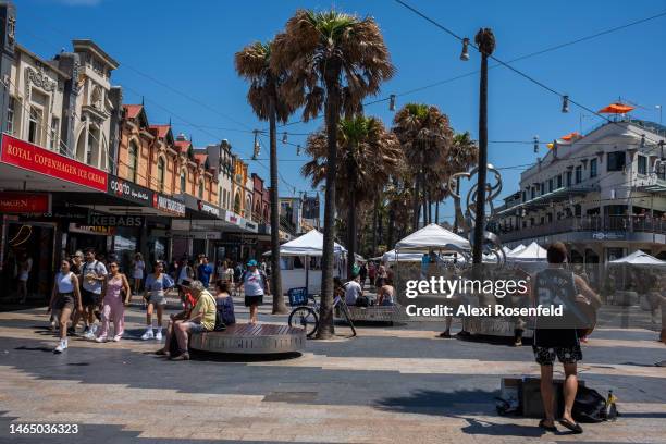 People walk past shops near the Manly beach on February 11, 2023 in Sydney, Australia. Hundreds flocked to the beach as temperatures reached above 80...