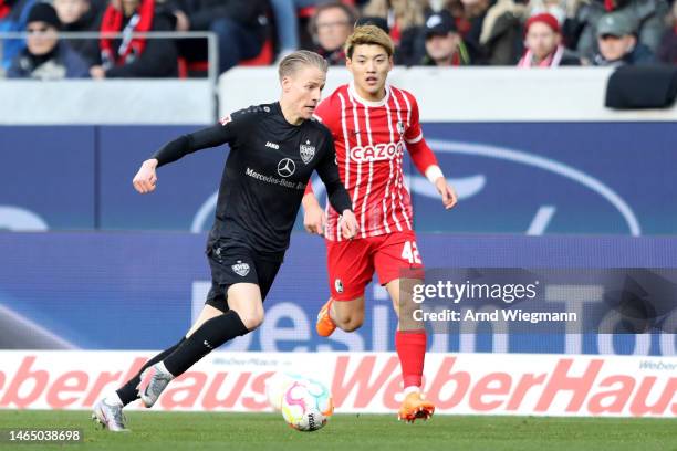 Chris Fuehrich of VfB Stuttgart runs with the ball while under pressure from Ritsu Doan of SC Freiburg during the Bundesliga match between Sport-Club...