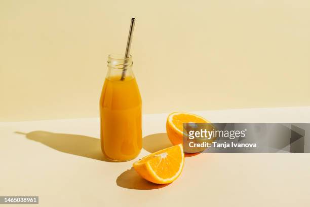 colorful bottle of freshly squeezed orange juice with fresh ingredients oranges on beige background. superfoods, healthy food, drinks, diet and detox concept. flat lay, top view, copy space - orange juice stock pictures, royalty-free photos & images