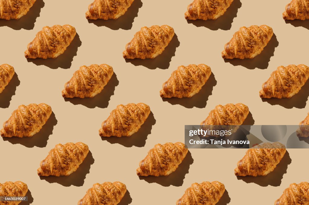 Creative layout with croissants. Pattern of bakery products handmade on beige background. Modern minimal food photography collage in pop-art style. Flat lay, top view