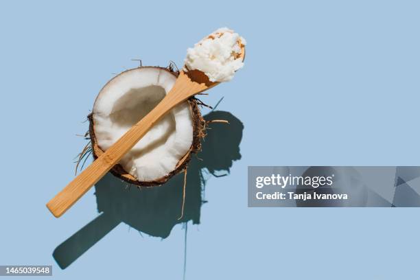 ripe coconuts, coconut oil on blue background. health and wellness concept. minimal flat lay style. top view, copy space. - huile de coco photos et images de collection