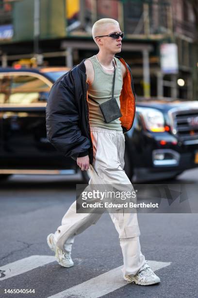 Guest wears black sunglasses, a black ribbed velvet crossbody bag from Jacquemus , silver necklaces, a pale green ribbed tank-top, a black with...
