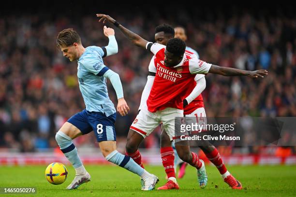 Mathias Jensen of Brentford battles for possession with Thomas Partey of Arsenal during the Premier League match between Arsenal FC and Brentford FC...