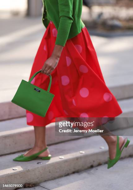 Olivia Joan seen wearing Kate Spade knit green top and cardigan, Kate Spade red long skirt with pink polka dot pattern, Kate Spate green leather bag...