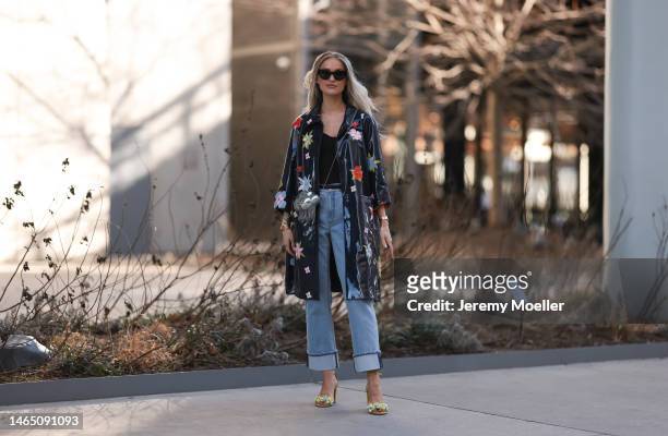 Victoria Magrath seen wearing Saint Laurent black sunglasses, black off-shoulder top, black shiny leather small belt, blue faded denim large...