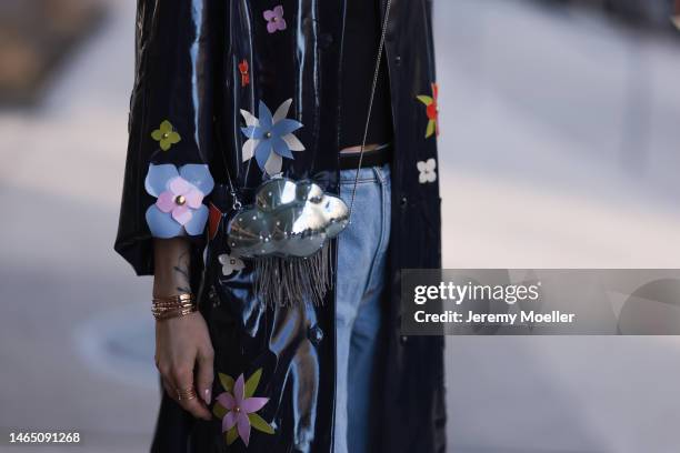 Victoria Magrath seen wearing black shiny leather small belt, blue faded denim large rolled-up flared pants, Kate Spade navy blue shiny varnished...