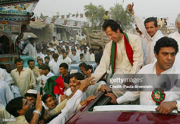 Imran Khan , cricket captain turned politician and chairman of the Dhirir Tehrik-e-Insaf political party, shakes hands with supporters during a rally...