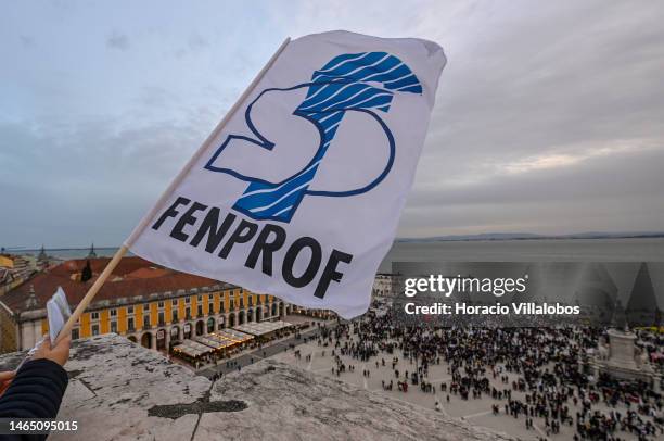 Demonstrator waves a trade union flag from the top of the Rua Augusta Arch as teachers arrive in Praça do Comercio at the end of the rally to protest...