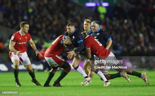 Finn Russell of Scotland is tackled by Christ Tshiunza of Wales during the Six Nations Rugby match between Scotland and Wales at Murrayfield Stadium...