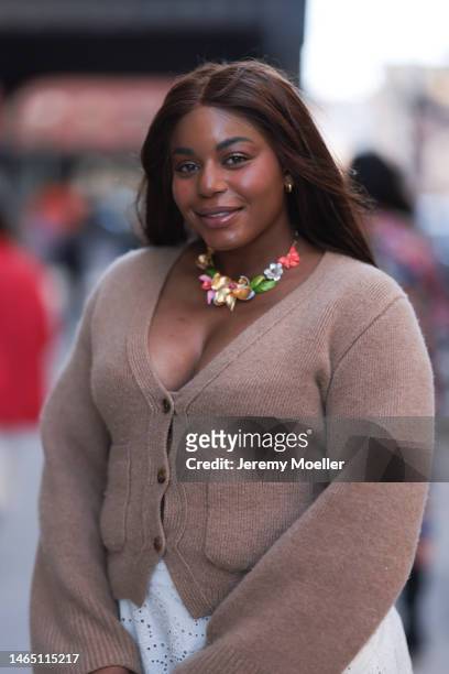 Guest is seen wearing Kate Spade multicolored flower statement necklace, gold earrings, brown knit cardigan, outside the Kate Spade presentation on...