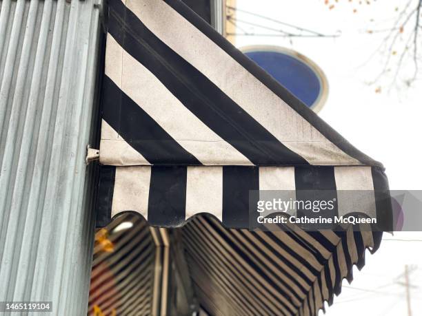 side profile view of striped business awning in small town - striped awning stock pictures, royalty-free photos & images