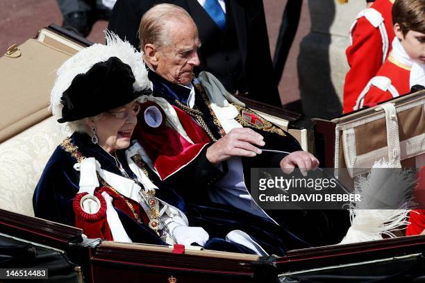 Britain's Queen Elizabeth II and Prince Philip, Duke of Edinburgh, ride in a carriage after leaving St George's Chapel following the service of the...