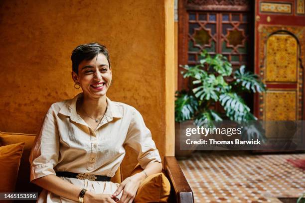 medium shot portrait smiling woman relaxing in riad while on vacation - trip photos et images de collection