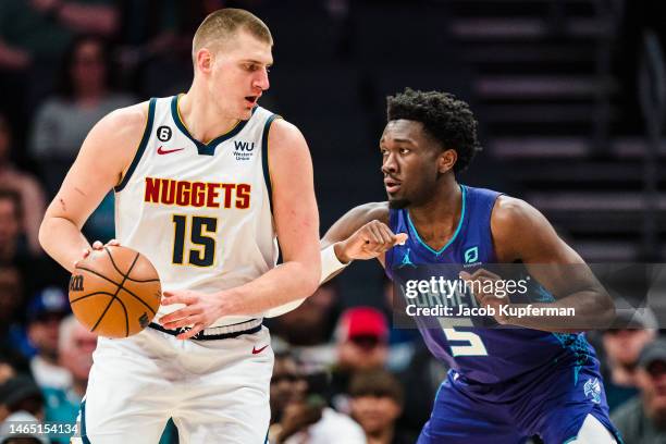 Mark Williams of the Charlotte Hornets guards Nikola Jokic of the Denver Nuggets in the first quarter during their game at Spectrum Center on...