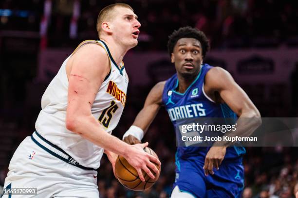 Nikola Jokic of the Denver Nuggets drives to the basket while guarded by Mark Williams of the Charlotte Hornets in the third quarter during their...