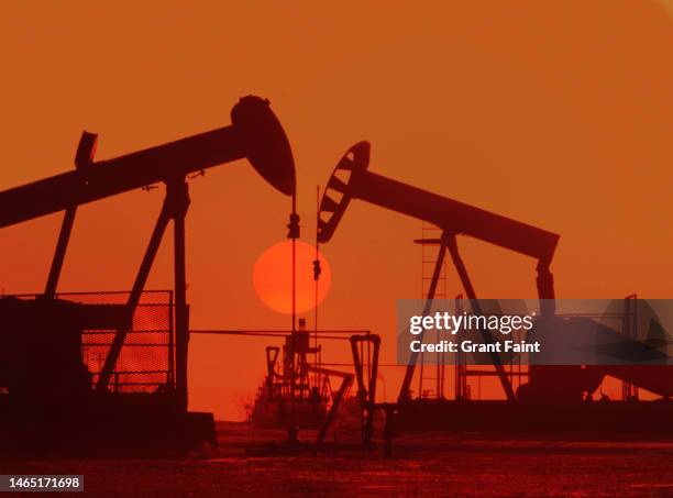 sunrise and oil pumpjacks - taladro fotografías e imágenes de stock