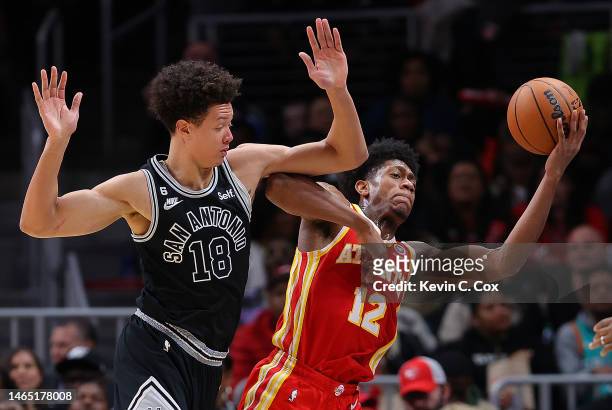 De'Andre Hunter of the Atlanta Hawks draws a foul as he battles for a loose ball against Isaiah Roby of the San Antonio Spurs during the third...