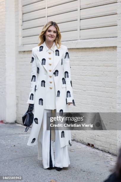 Actress Meghann Fahy wears embroidered white coat, button up jacket, pants, black bag outside Proenza Schouler during New York Fashion Week on...