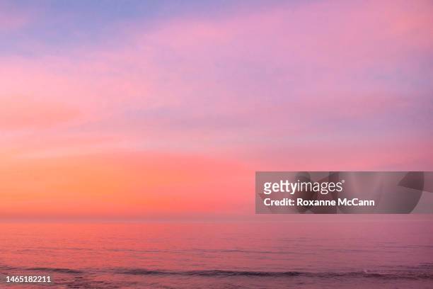The rising sun illuminates the cloudy sky over the Pacific Ocean and is reflected in the water in October 1998 in Malibu, California