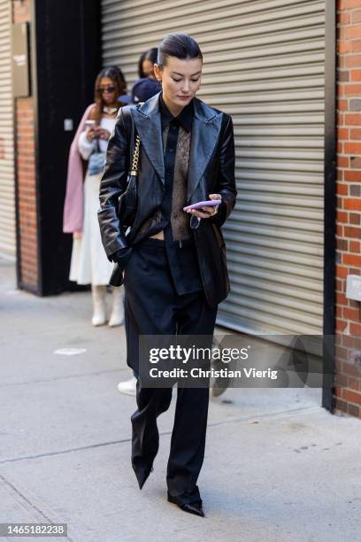 Amalie Gassmann wears black leather jacket, see trough laced top pants, bag outside Proenza Schouler during New York Fashion Week on February 11,...