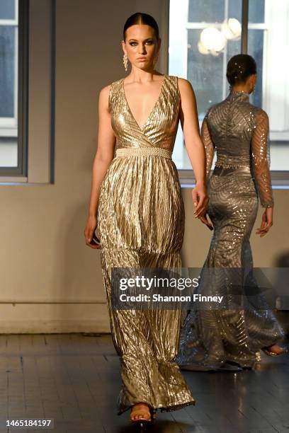 Model wears a Grecian-inspired sleeveless gold metallic column dress with a surplice wrap bodice and pleated skirt at the Dell Scott runway show...