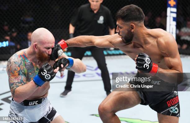 Yair Rodriguez of Mexico punches Josh Emmett in the UFC interim featherweight championship fight during the UFC 284 event at RAC Arena on February...