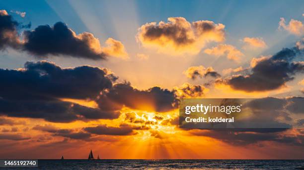 scenic sunset above mediterranean sea, with distant view of sailing yacht - sunset stock pictures, royalty-free photos & images