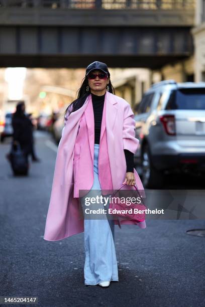 Miki Cheung wears a black shiny leather cap, pink sunglasses, gold and rhinestones logo pendant earrings from Valentino, a black turtleneck pullover,...