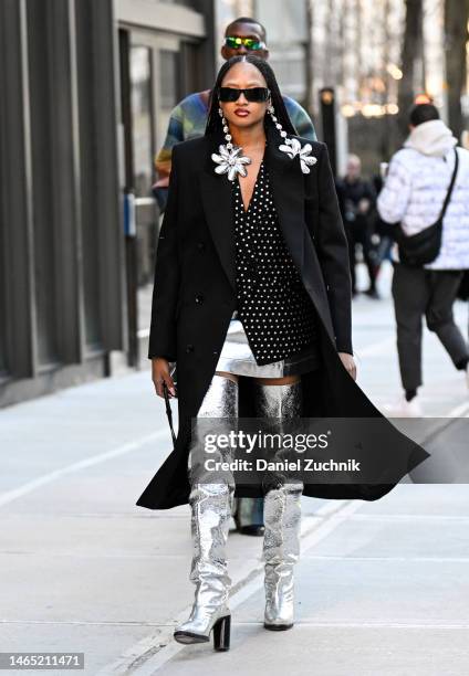 Candace Marie is seen wearing a black coat, polka dot blouse, silver skirt and silver boots with Area earrings outside the Area show during New York...