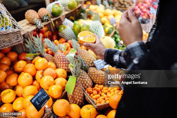 midsection of man buying fruits in supermarket. - vitamine c stockfoto's en -beelden