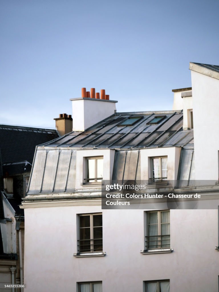 Close-up of a Parisian building with its zinc roof and white facade