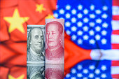 Trade tension, trade war, commercial conflict between US and China, economic concept : US dollar bill and Chinese yuan. Depicting a significant deterioration in the relationship between US and China.