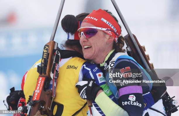 Silver medalist, Denise Herrmann-Wick of Germany embraces gold medalist Julia Simon of France after crossing the finish line in the Women 10 km...